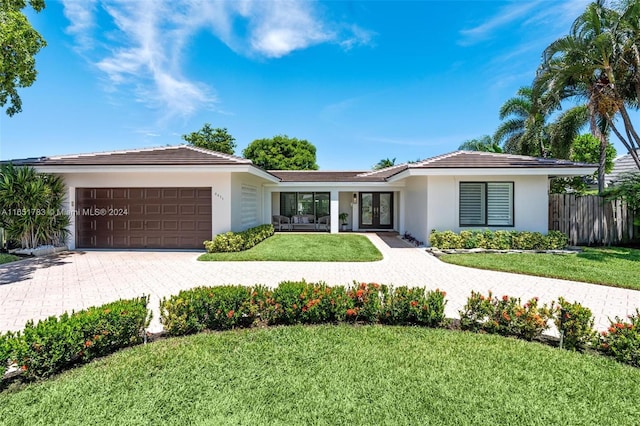 ranch-style house with french doors, a front yard, and a garage