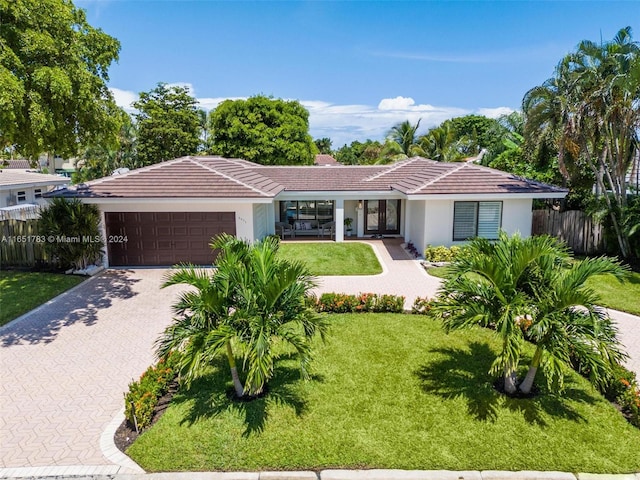 single story home featuring a garage and a front yard