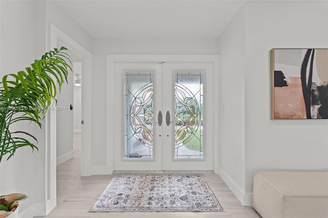 foyer with light wood-type flooring and french doors