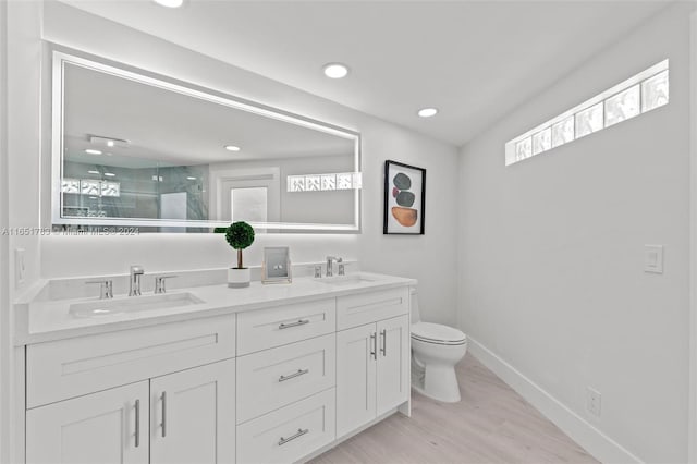 bathroom featuring vanity, hardwood / wood-style flooring, toilet, and a shower with shower door