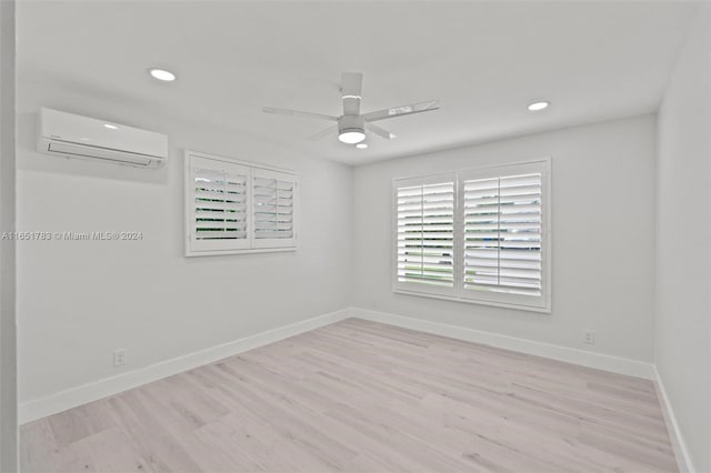 empty room with an AC wall unit, ceiling fan, and light wood-type flooring