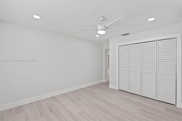 unfurnished bedroom featuring ceiling fan, light hardwood / wood-style floors, and a closet