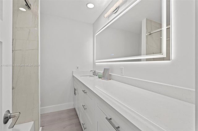 bathroom with vanity, wood-type flooring, and tiled shower / bath combo