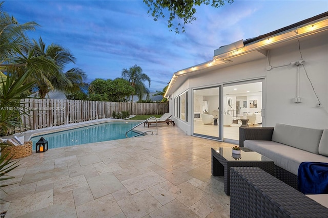 pool at dusk featuring outdoor lounge area and a patio