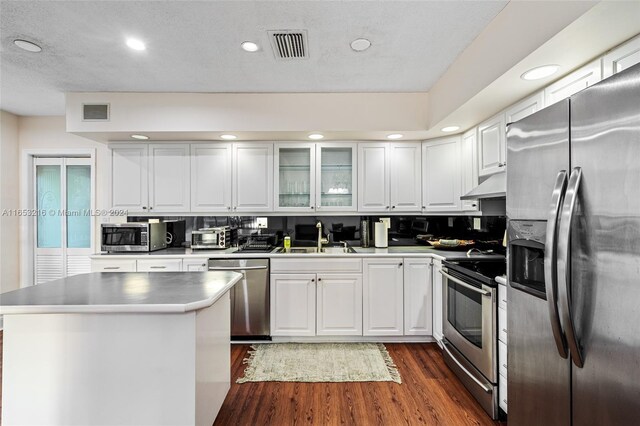 kitchen with stainless steel appliances, dark hardwood / wood-style flooring, white cabinetry, and sink