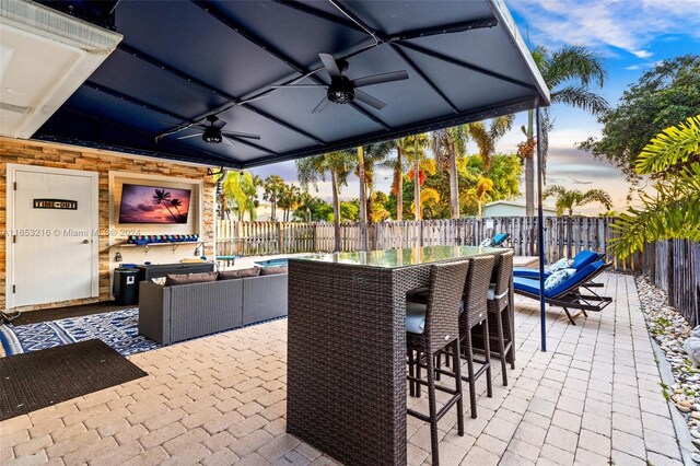 patio terrace at dusk with ceiling fan and an outdoor hangout area