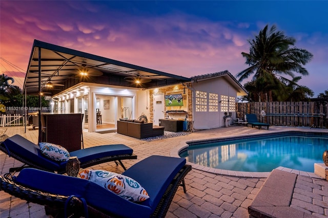 pool at dusk featuring an outdoor living space and a patio area