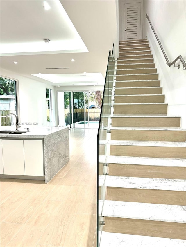 staircase with sink and hardwood / wood-style flooring