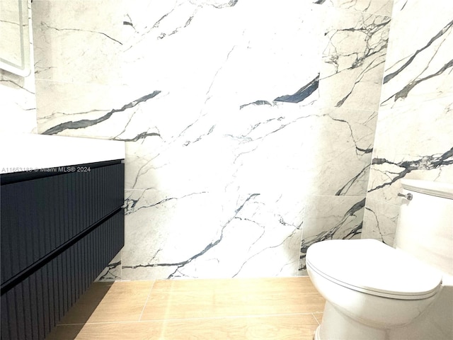 bathroom with tile walls, vanity, and toilet