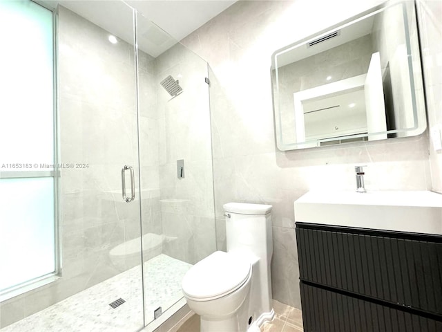 bathroom featuring tile walls, walk in shower, vanity, and toilet