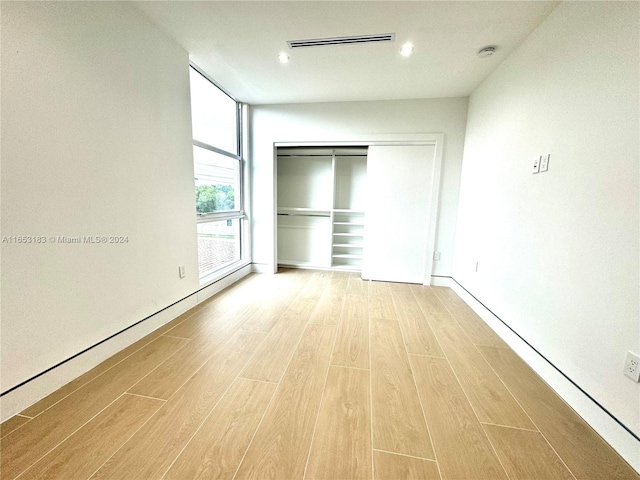 unfurnished bedroom with a closet and light wood-type flooring