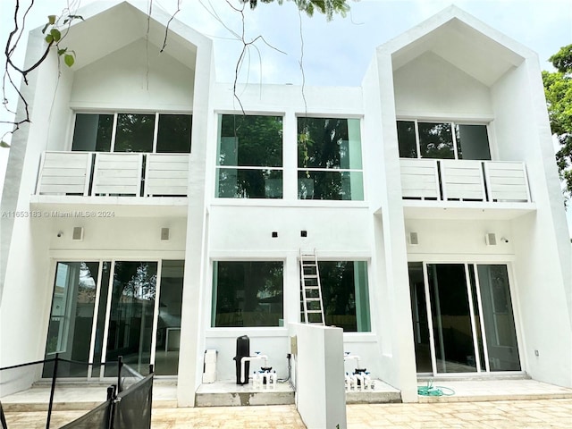 back of property with a balcony and a patio