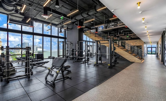 gym with a towering ceiling, a wealth of natural light, and floor to ceiling windows