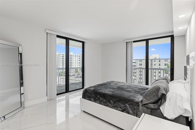 bedroom featuring multiple windows, floor to ceiling windows, and access to exterior