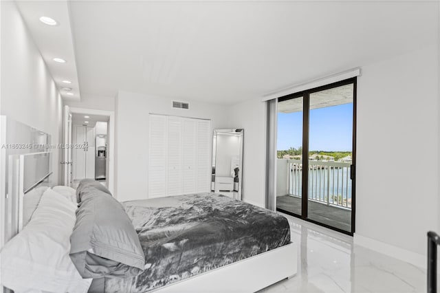 bedroom with a closet, stainless steel fridge with ice dispenser, and access to outside