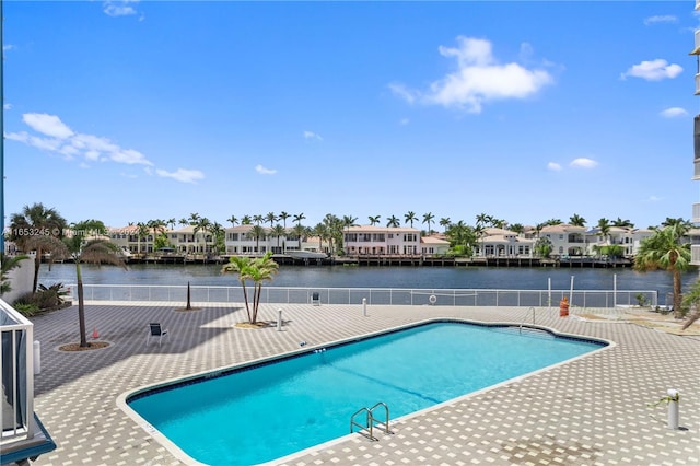 view of swimming pool featuring a water view and a patio area