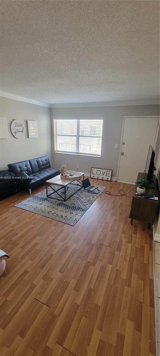 unfurnished living room with wood-type flooring and a textured ceiling