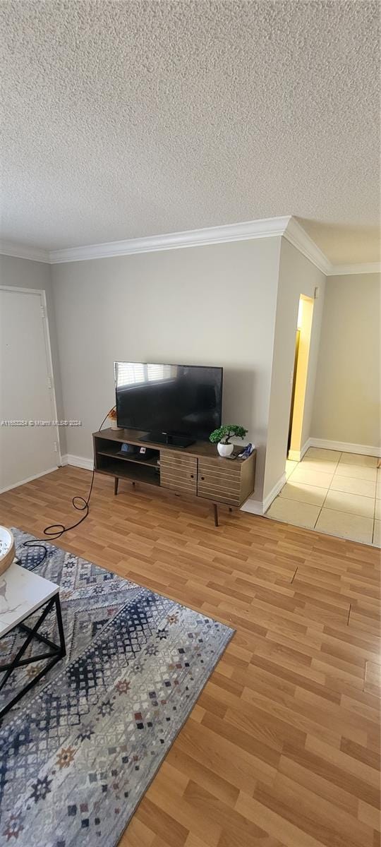 living room with hardwood / wood-style flooring, crown molding, and a textured ceiling