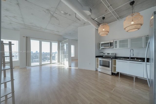 kitchen featuring pendant lighting, stainless steel appliances, sink, and wood-type flooring