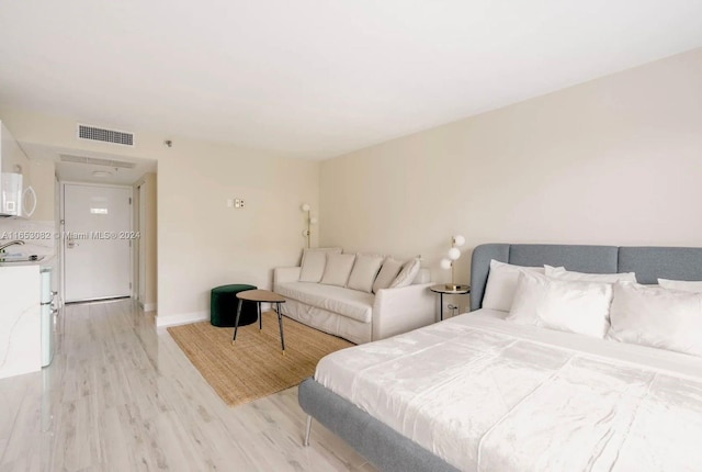 bedroom with light hardwood / wood-style flooring and sink