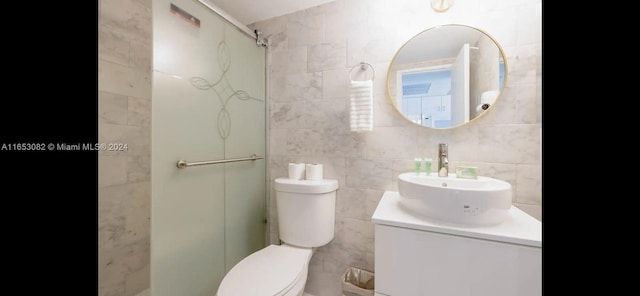 bathroom featuring a shower, tile walls, toilet, and vanity