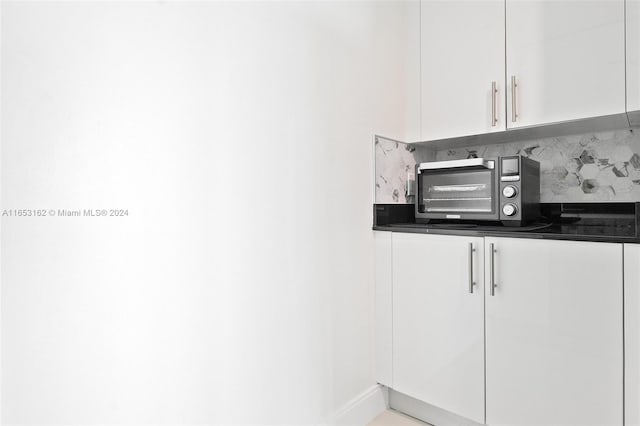 interior space featuring white cabinets and tasteful backsplash