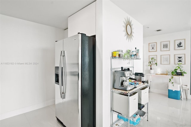 kitchen featuring white cabinetry and stainless steel fridge