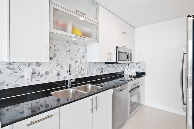 kitchen featuring stainless steel appliances, sink, tasteful backsplash, and white cabinetry