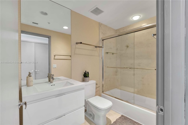 full bathroom with tile patterned flooring, enclosed tub / shower combo, toilet, and vanity