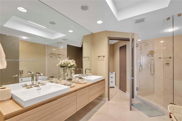 bathroom featuring tile patterned floors, a tray ceiling, walk in shower, and vanity