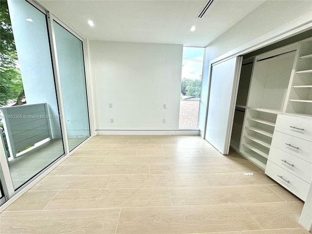 hall with light wood-type flooring and floor to ceiling windows