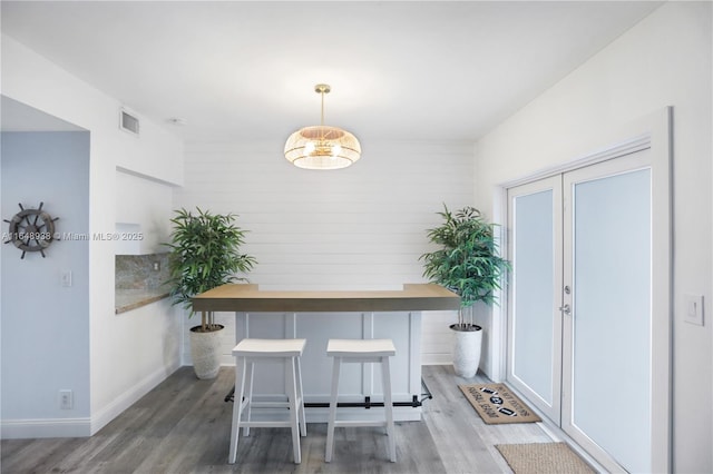 unfurnished dining area featuring visible vents, baseboards, and wood finished floors