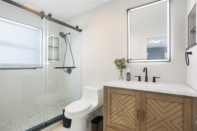 bathroom with a shower stall, toilet, and vanity