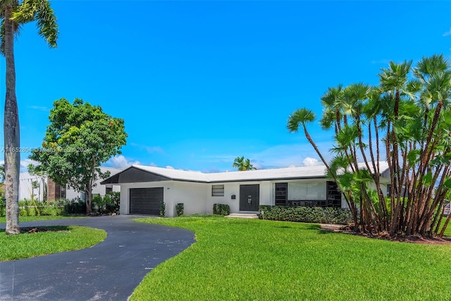 single story home with a garage and a front lawn