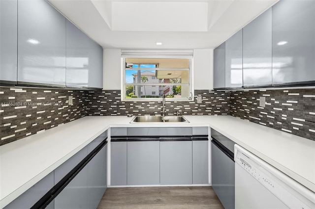 kitchen with backsplash, dishwasher, dark hardwood / wood-style floors, and sink