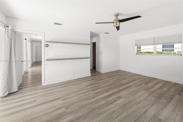 empty room with ceiling fan and light hardwood / wood-style floors