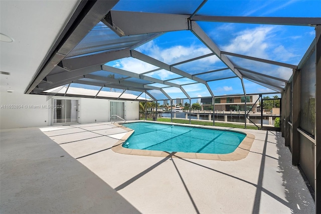 view of swimming pool featuring a lanai, a patio, and a water view