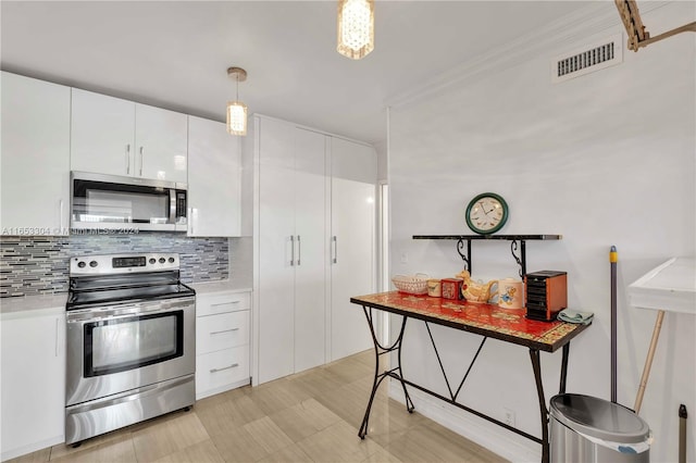 kitchen featuring white cabinets, crown molding, stainless steel appliances, pendant lighting, and tasteful backsplash