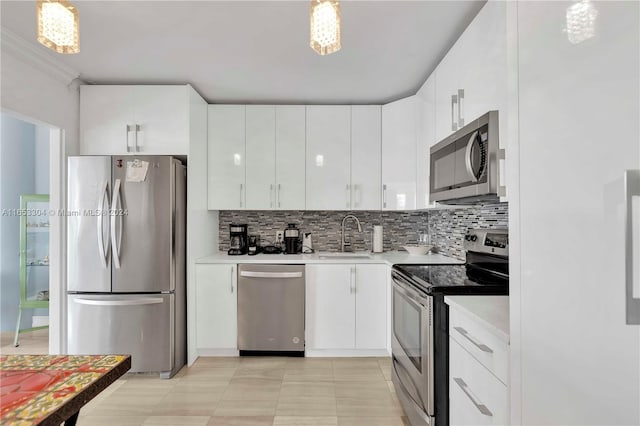 kitchen featuring decorative light fixtures, appliances with stainless steel finishes, and white cabinetry