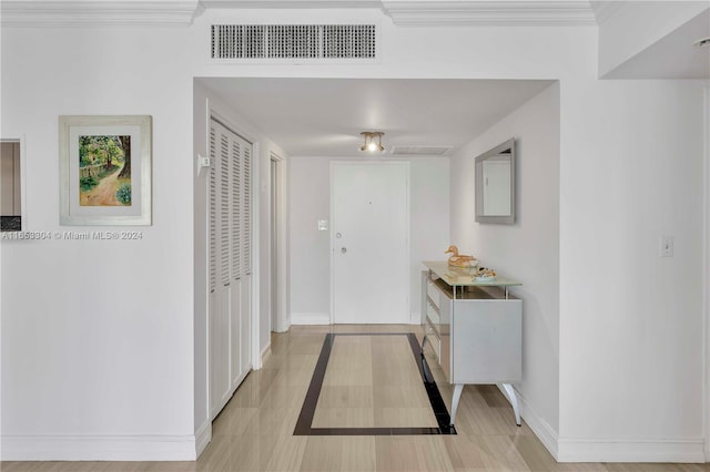 interior space with light tile patterned floors and crown molding