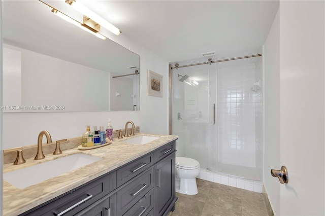 bathroom with vanity, toilet, a shower with shower door, and tile patterned flooring