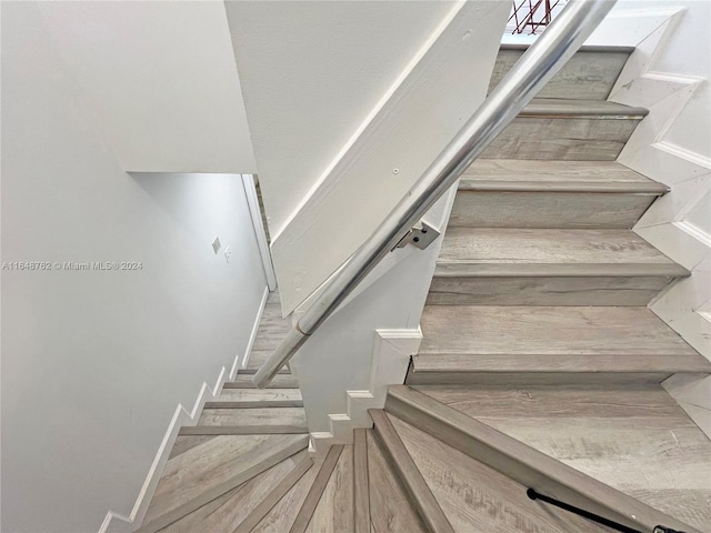 staircase with hardwood / wood-style floors