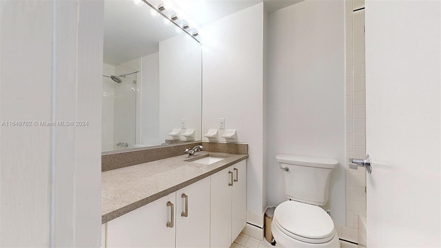 bathroom with vanity, toilet, tile patterned floors, and a shower