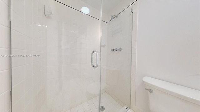 bathroom with a shower with shower door and toilet