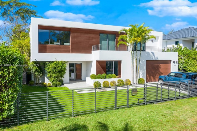 back of house with a lawn, a garage, and a balcony