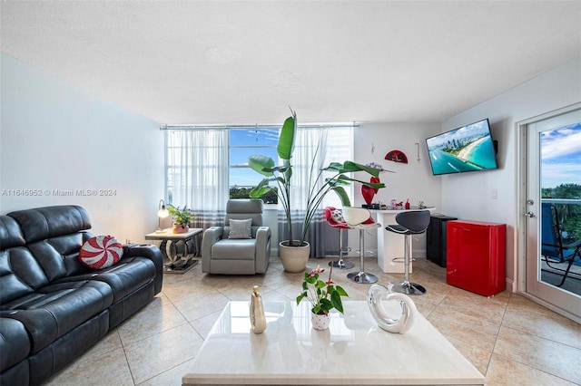 living room featuring tile patterned flooring, a healthy amount of sunlight, and a textured ceiling