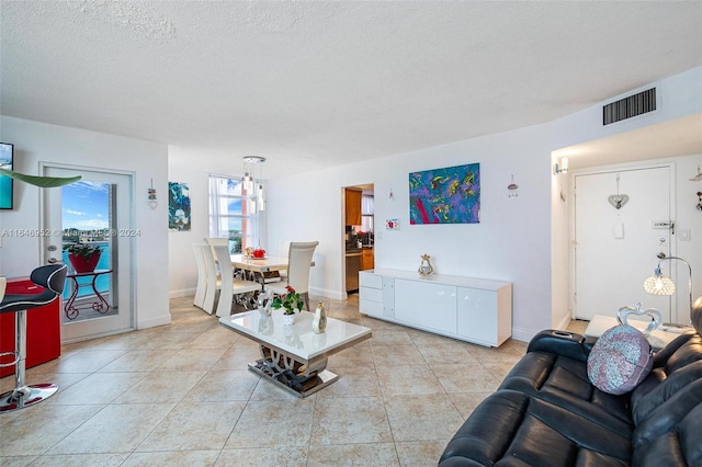 living room with a textured ceiling and light tile patterned floors