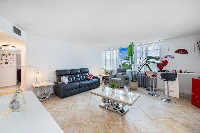 tiled living room featuring floor to ceiling windows