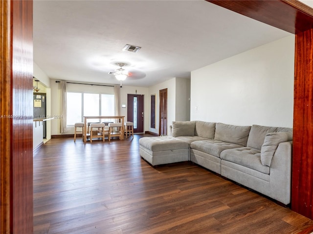 living room with dark hardwood / wood-style flooring and ceiling fan