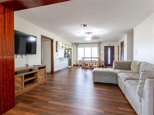 living room featuring ceiling fan and dark hardwood / wood-style flooring